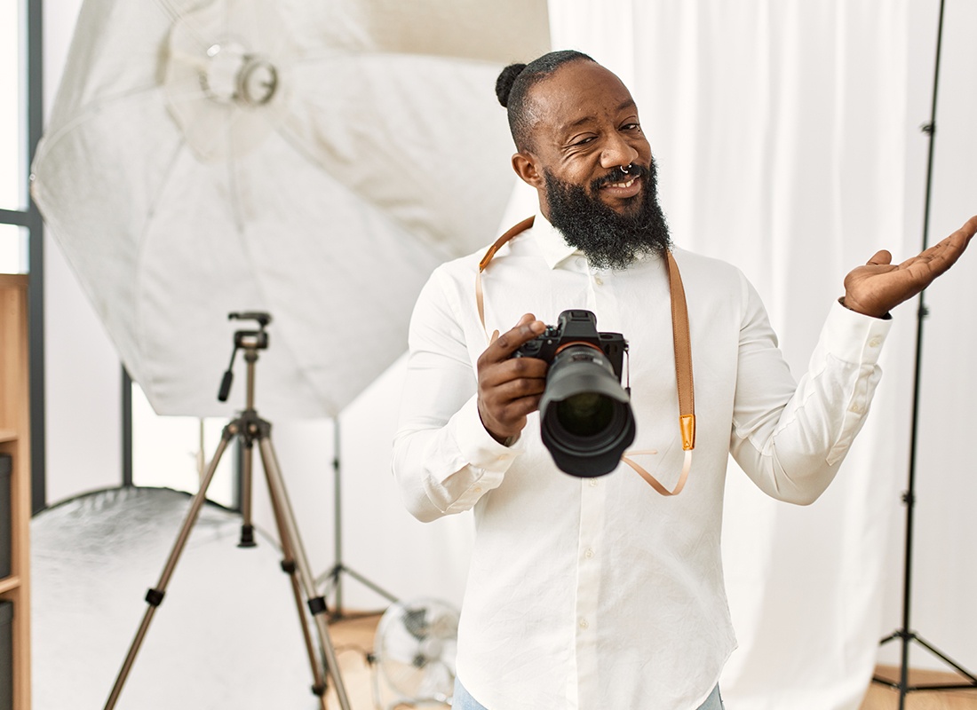 Business Insurance - Cheerful Man Prepares His Photography Studio