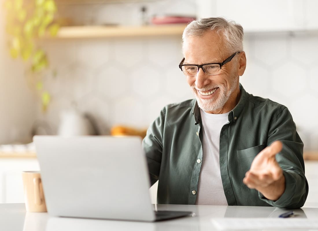 Contact - Cheerful Man Uses a Laptop to Have a Virtual Chat at Home