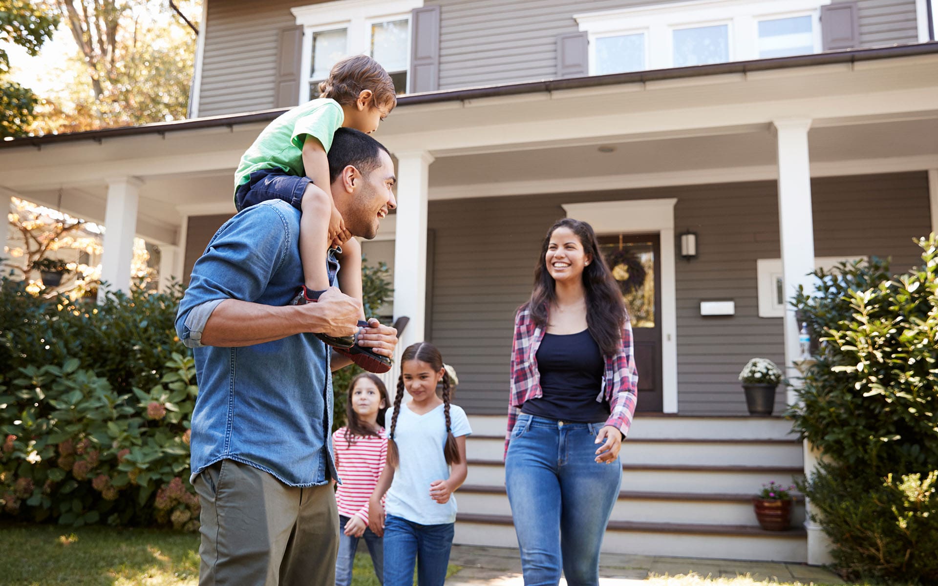 Enuff Insurance Inc - Happy Family Walking Outside in Front of Their Home